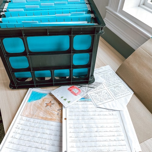 Photo of teacher's file folder crate and student work samples for writing report card comments