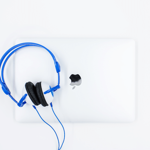 Photo of blue headphones on Macbook laptop 