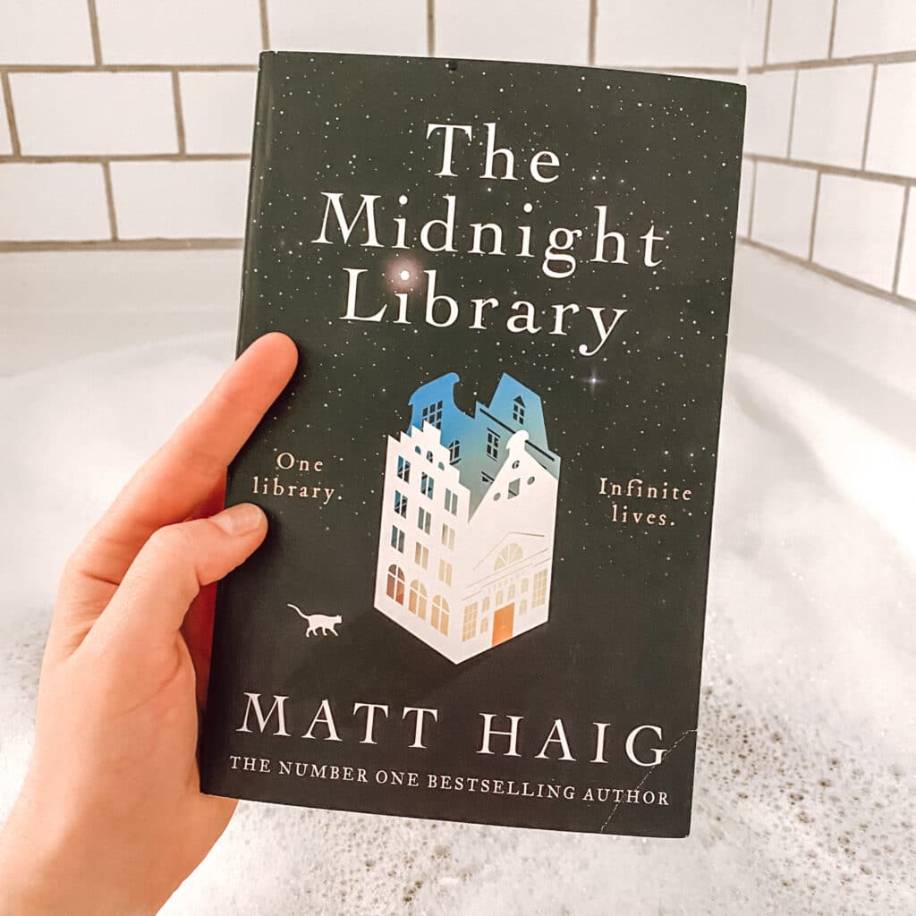 Holding the book "The Midnight Library" over a bubble bath, favourite part of my evening routine