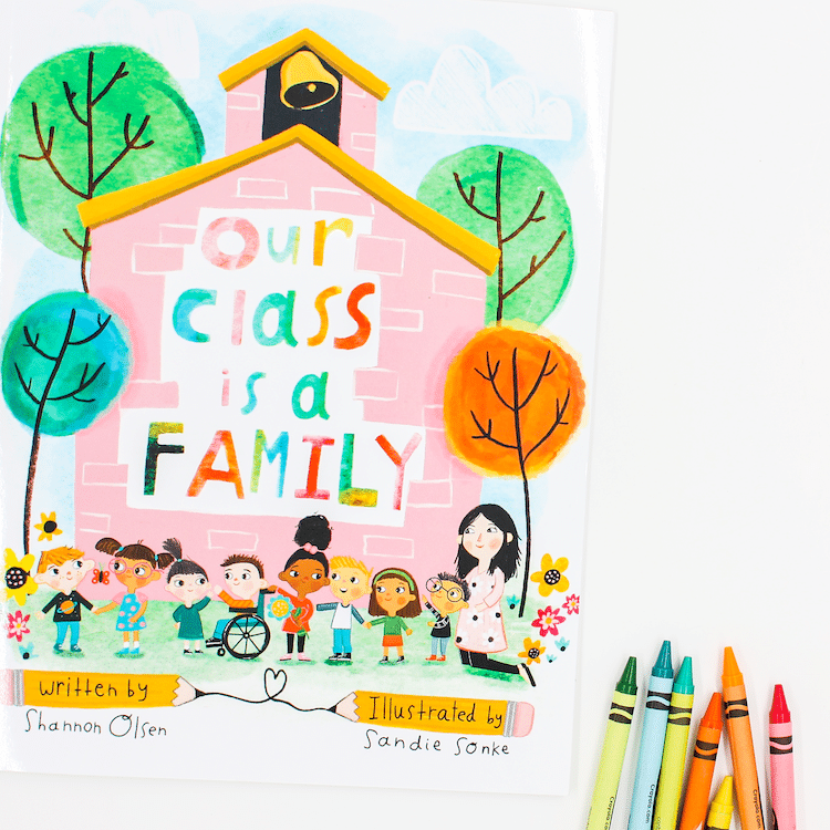 Photo of book titled "Our Class Is A Family" with crayons
