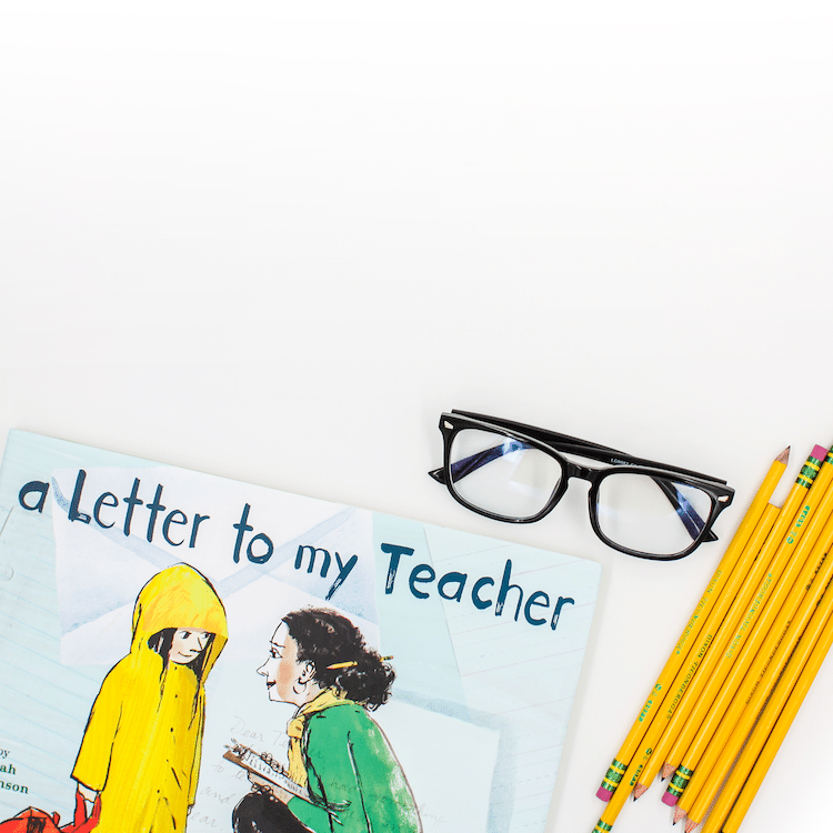 Photo of book titled "A Letter To My Teacher" with glasses and pencils on a desk