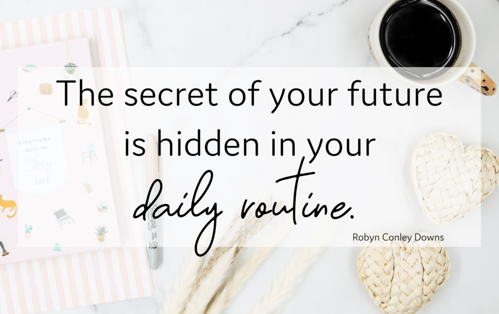 Quote graphic that reads "The secret of your future is hidden in your daily routine" over a flatlay of a cup of coffee and rattan hearts.
