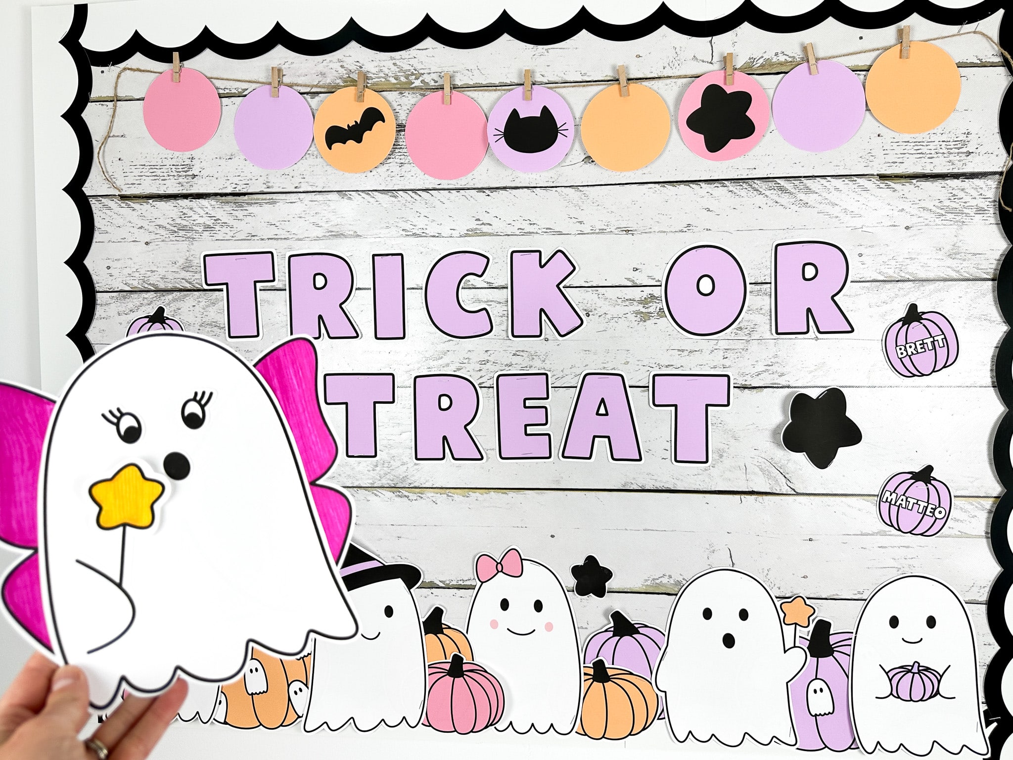 Ghost bulletin board with message that reads "trick or treat" featuring a ghost craft in front with pink fairy wings and a wand- showing one of two Halloween bulletin board ideas