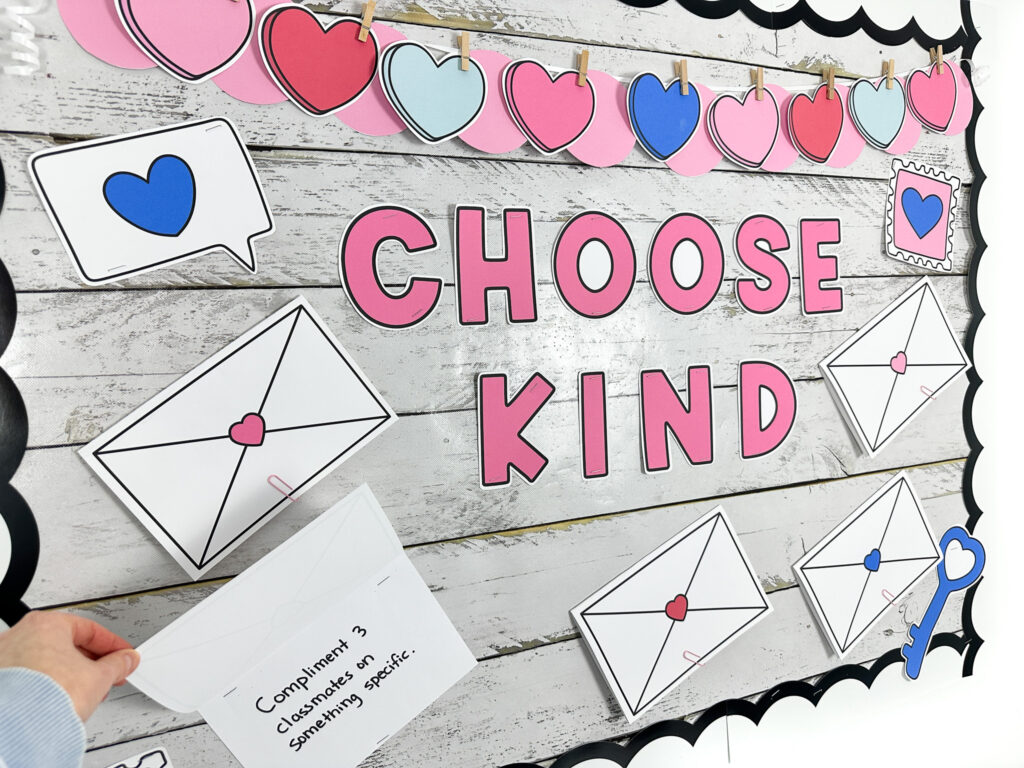 Photo of random acts of kindness week bulletin board where an envelope is opened to reveal one of the act of kindness challenges to the class