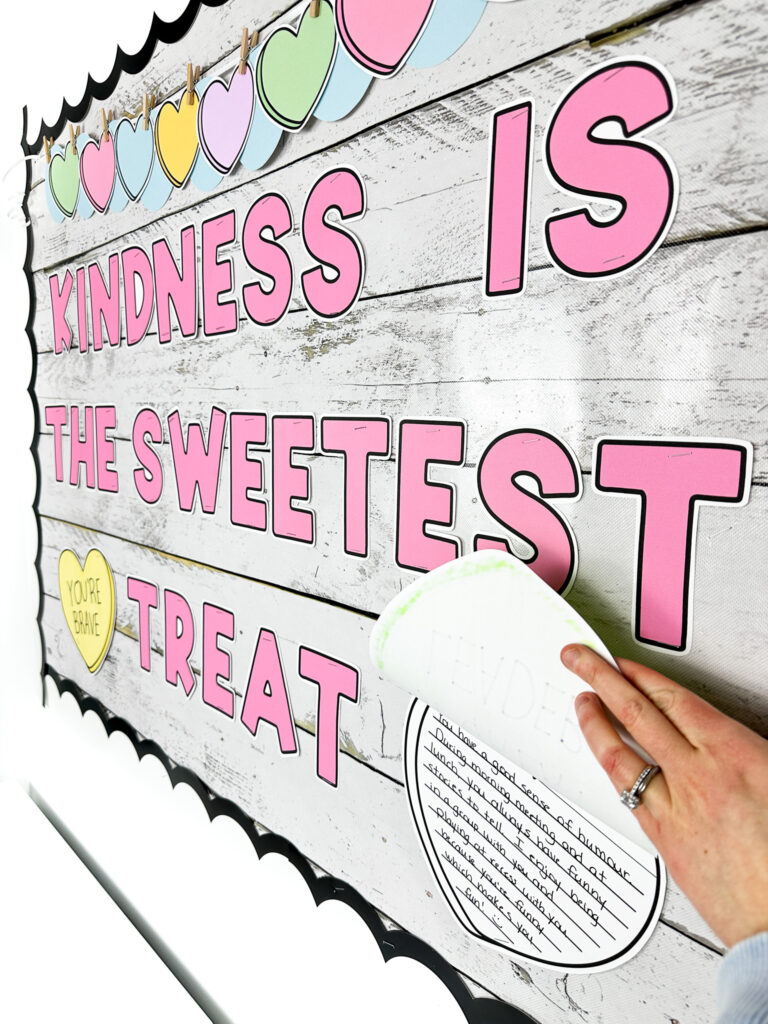 Sideways shot of the sweethearts bulletin board showing a writing sample underneath the candy heart student craft