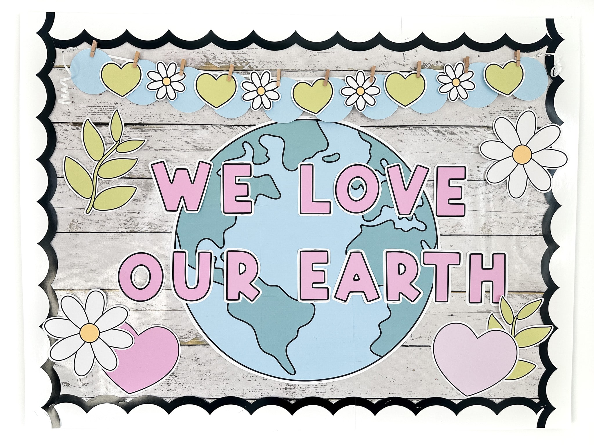 Earth Day bulletin board with a large Earth, daisies, hearts, and plants