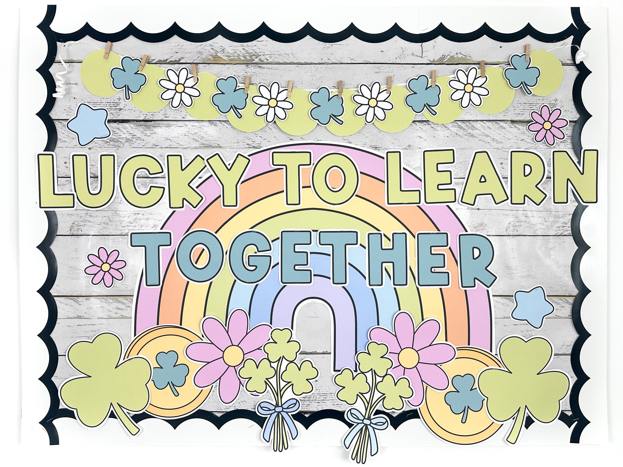 St Patrick's day bulletin board with message "lucky to learn together" with a big rainbow, shamrocks, gold coins and daisies in bright spring colours