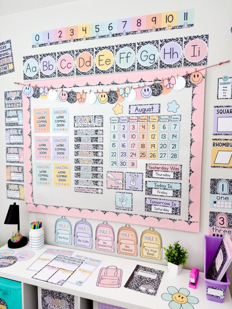 another composition notebook classroom decor bundle mock up from a different angle showing class schedule, calendar, alphabet posters, clock labels, levels of understanding, number line, number posters, class rules, hand signals, and more