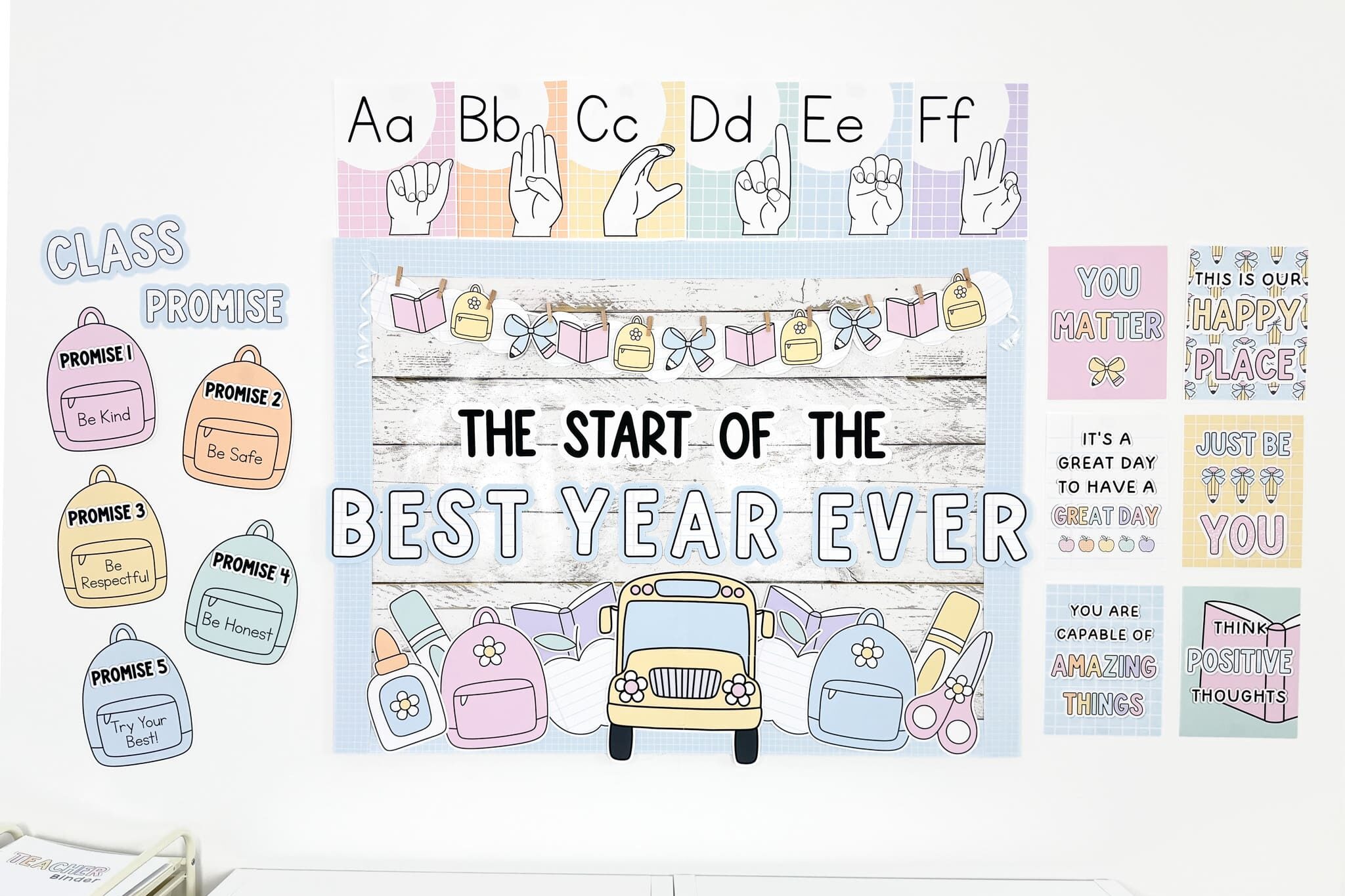 pastel classroom decor bulletin board saying the start of the best year ever with a large school bus, backpacks, pencils, books